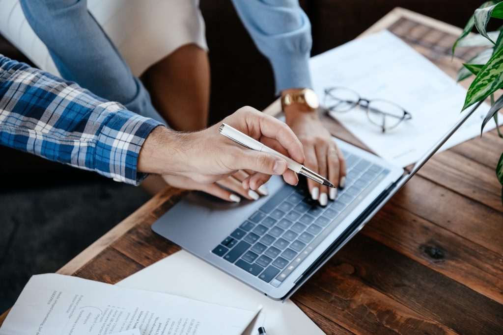 Lady and mans hands pointing at a laptop